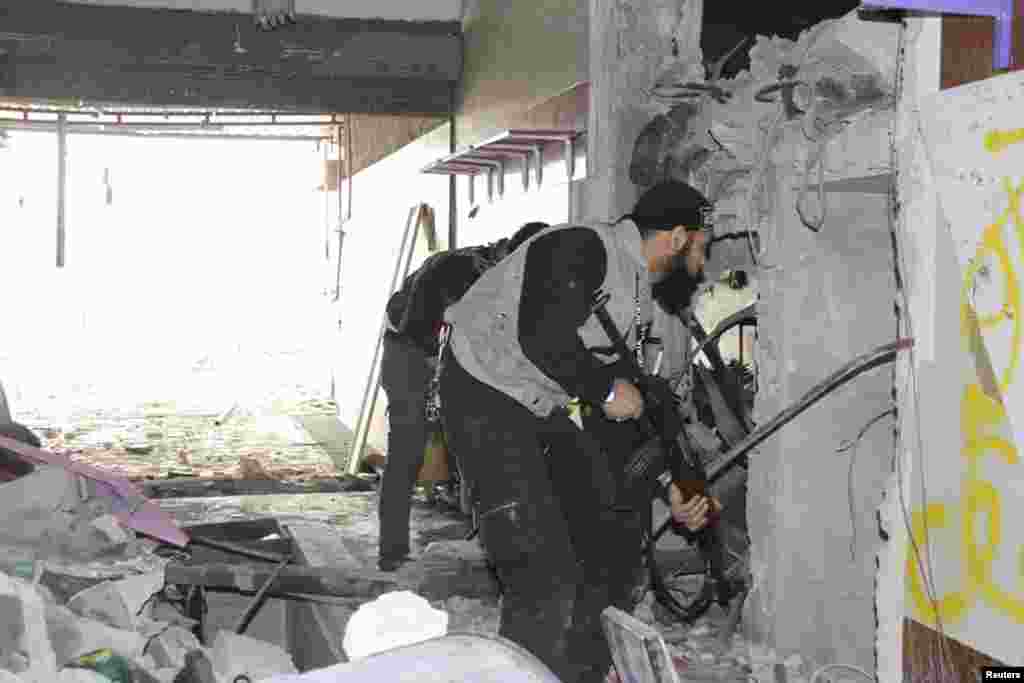 Free Syrian Army fighters inside a damaged shop in Sidi Meqdad area in the suburbs of Damascus, Syria, March 31, 2013. 