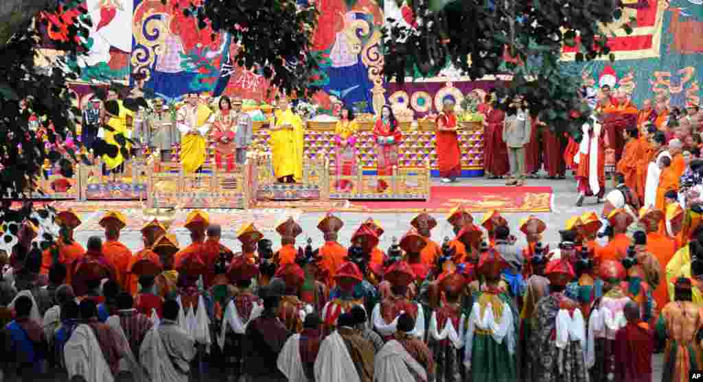 King of Bhutan Jigme Khesar Namgyel Wangchuck (2L) and future queen Jetsun Pema (3L) stand together during their marriage ceremony in the main courtyard of the 17th-century fortified monastery or dzong in Punakha. (AFP)
