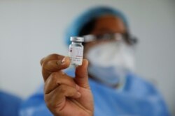 Un trabajador de salud muestra un frasco de la vacuna AstraZeneca (SKBio Corea) bajo el esquema COVAX contra la enfermedad del nuevo coronavirus en un centro de salud pública en San Salvador, el 12 de marzo de 2021.