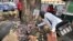 A man lays flowers at a tree on the street of Abidjan where at least 60 persons died in a stampede among crowds gathered for celebratory New Year's Eve fireworks, January 2, 2013.