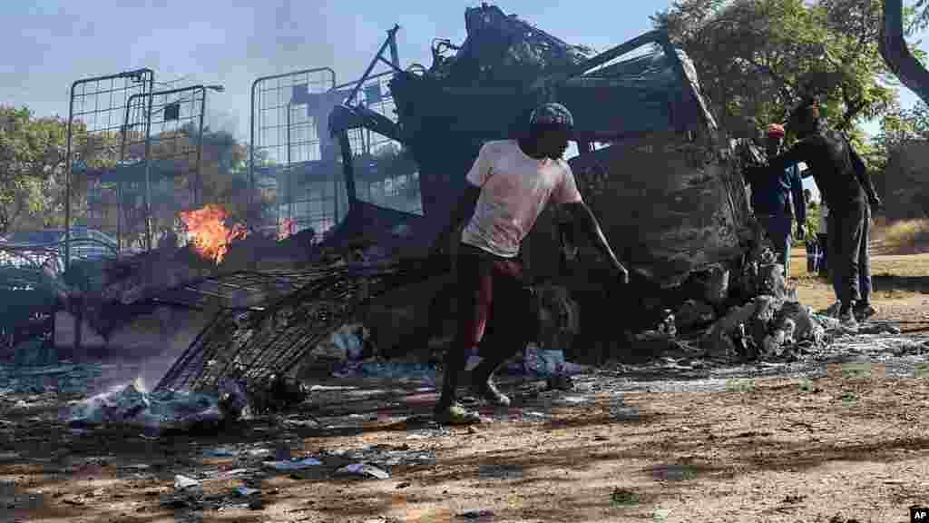 Un habitant passe devant un camion incendié près de la route où les manifestants sont passés à Atteridgeville, à l&#39;ouest de Pretoria, Afrique du Sud, le 21 juin 2016.