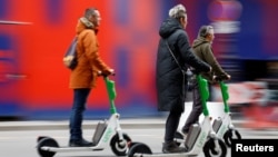 People ride electric scooters by Lime sharing service, on the eve of a public vote on whether or not to ban rental electric scooters, in Paris, France, April 1, 2023. (REUTERS/Sarah Meyssonnier)