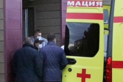 FILE - Kremlin critic Alexei Navalny, not seen in photo, is transferred on a stretcher into an ambulance before being driven to an airport for a medical evacuation to Germany, at the Omsk Hospital, in Omsk, Russia, Aug. 22, 2020.