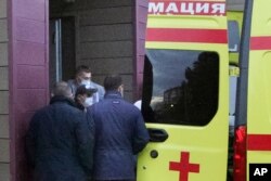 FILE - Kremlin critic Alexei Navalny, not seen in photo, is transferred on a stretcher into an ambulance before being driven to an airport for a medical evacuation to Germany, at the Omsk Hospital, in Omsk, Russia, Aug. 22, 2020.