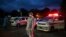 This photo taken on October 17, 2020 shows volunteers wearing personal protective equipment (PPE) waiting next to ambulances as they prepare to transfer local residents suspected of having the COVID-19 coronavirus to a quarantine centre in Yangon. (Photo
