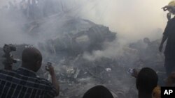 People use mobile phones to photograph wreckage of Dana Air flight 9J-922, Lagos, Nigeria, June 3, 2012.