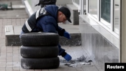 A police expert examines the remnants of a suspicious object after it was defused by sappers on a street in Kyiv, Ukraine, April 2, 2015.