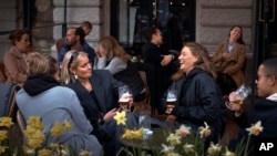 FILE - In this Wednesday, April 8, 2020 file photo people chat and drink outside a bar in Stockholm, Sweden. 