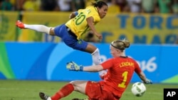 Brazil's Marta (L) leaps over Sweden goalkeeper Hedvig Lindahl as she attempts a shot on goal during a group E match of the women's Olympic football tournament between Sweden and Brazil at the Rio Olympic Stadium in Rio De Janeiro, Brazil, Aug. 6, 2016. B