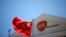 A Chinese national flag flutters in front of a GlaxoSmithKline (GSK) office building in Shanghai, July 12, 2013.