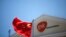 A Chinese national flag flutters in front of a GlaxoSmithKline (GSK) office building in Shanghai, July 12, 2013.