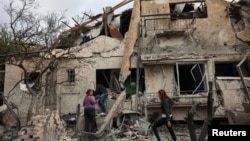 People check their family's damaged house at the scene where one of the projectiles fell, after they crossed over to Israel from Lebanon, amid ongoing hostilities between Hezbollah and Israel, in Rinatiya, Israel, Nov. 24, 2024.