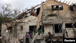 People check their family's damaged house at the scene where one of the projectiles fell, after they crossed over to Israel from Lebanon, amid ongoing hostilities between Hezbollah and Israel, in Rinatiya, Israel, Nov. 24, 2024.