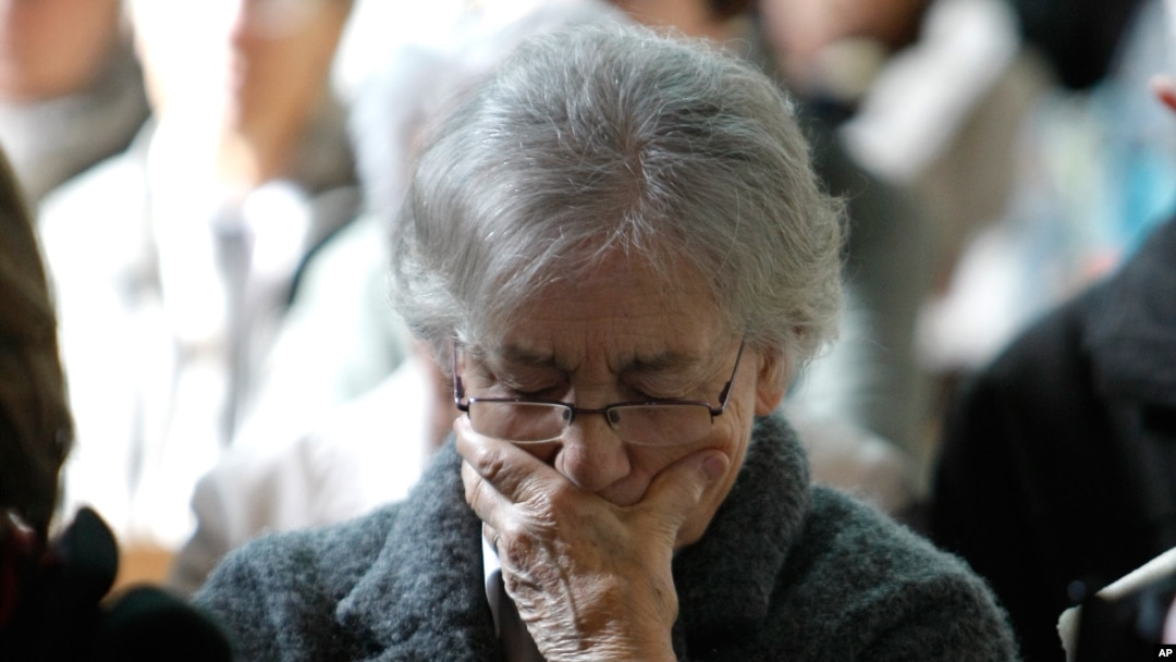 Seorang perempuan menundukkan kepalanya di sebuah kebaktian mengenang para korban jatuhnya pesawat Germanwings. Kebaktian khusus ini berlangsung Notre Dame de Bourg, in Digne-les-Bains (28/3).