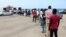 FILE - Migrants queue to receive food aid distributed by UNHCR, in Tripoli, Libya, May 12, 2020. 
