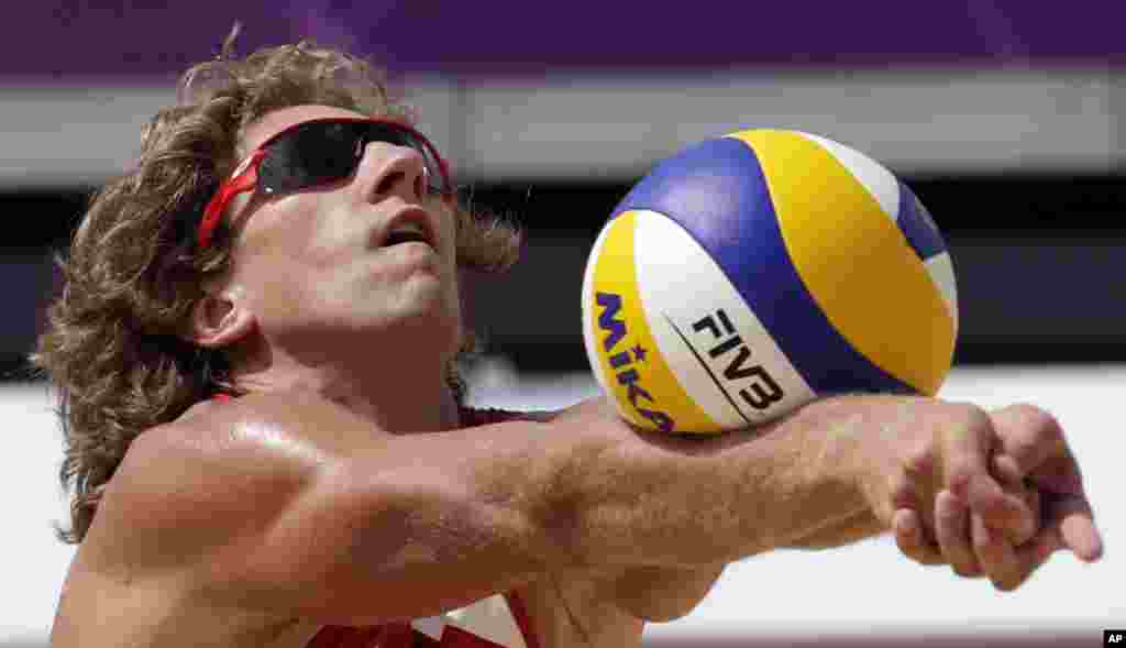 Aleksandrs Samoilovs de Latvia pone una pelota durante el juego del volibol masculino contra Sudáfrica.