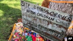 FILE - A makeshift memorial for the dozens of Indigenous children who died more than a century ago while attending a boarding school that was once located nearby is growing under a tree at a public park in Albuquerque, New Mexico, July 1, 2021. 