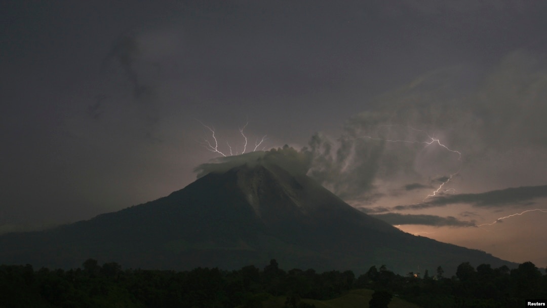 Petir menyambar saat Gunung Sinabung menyemburkan abu dan lava panas, di desa Simpang Empat, Karo, Sumatera Utara (18/9). 