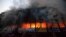 Locals and fire-fighters try to control a fire at a garment factory in Dhaka, March 6, 2014. 