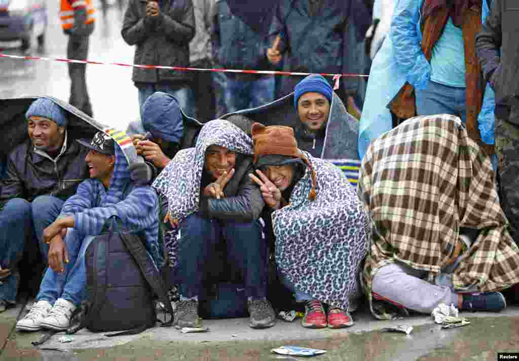 Migrants flash victory sign as they wait for buses in Nickelsdorf, Austria. Just two weeks after Austria&#39;s chancellor said his treatment of migrants was reminiscent of the Holocaust, Hungarian Prime Minister Viktor Orban made a surprise visit to Vienna on Friday, seeking support for further barricading his country&#39;s southern border.