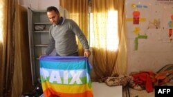 FILE - Issa Amro inspects an office of the Palestinian activist group Youth Against Settlements that was raided by Israeli troops in the occupied West Bank city of Hebron, Nov. 8, 2015.