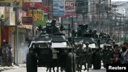 Government soldiers with armored personnel carriers move to reinforce the government forces battling the Moro National Liberation Front (MNLF) rebels in Zamboanga City, southern Philippines, Sept.10, 2013. 