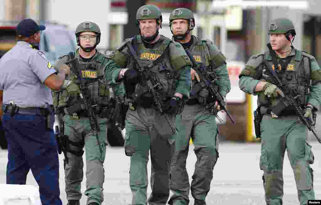 Law enforcement personnel walk near the scene where police officers were shot in Baton Rouge, Louisiana, U.S. July 17, 2016. 