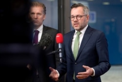 FILE - German Minister of State for European Affairs Michael Roth, right, speaks with the media as he arrives at the Europa building in Brussels, Dec. 11, 2018.
