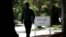 FILE - A man walks past a Google sign in Mountain View, California.