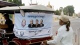 An election campaign poster of Prime Minister Hun Sen's ruling Cambodian People's Party hangs on the back of a motorized rickshaw parked at a blocked street in front of the Royal Palace in Phnom Penh.