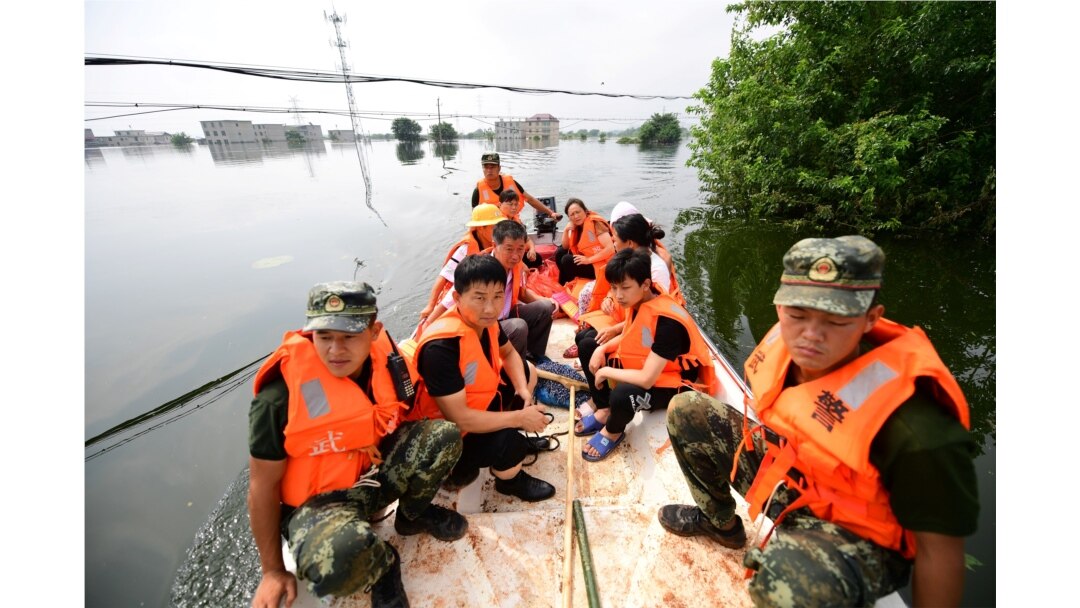 Paramilitary police officers evacuate residents from a flood-hit village with a boat in Yongxiu county of Jiujiang, Jiangxi province, China, July 14, 2020.