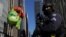 FILE - A member of the New York Police Department's Counterterrorism Bureau guard the parade route as a Grinch balloon floats by during the Macy's Thanksgiving Day Parade in Manhattan, New York, Nov. 23, 2017.