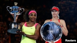 Petenis AS Serena Williams (kiri) dan petenis Rusia Maria Sharapova berpose dengan piala mereka seusai menyelesaikan pertandingan final Tenis Australia Terbuka 2015 di Melbourne (31/1). 