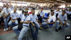 FILE - Workers of General Motors listen during a meeting with government officials at the company's plant in Valencia, Venezuela, April 20, 2017. 