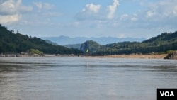 A yellow flag marks the site on the Mekong River in northern Laos where the government plans to build the Luang Prabang hydropower dam. (Zsombor Peter/VOA)