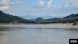 A yellow flag marks the site on the Mekong River in northern Laos where the government plans to build the Luang Prabang hydropower dam. (Zsombor Peter/VOA)