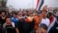 Manifestantes levantan la bandera nacional durante una protesta demandando mejores servicios públicos y trabajos en Basra, Iraq, el 11 de septiembre del 2018 