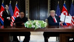 Presiden Donald Trump dan pemimpin Korea Utara dalam upacara penandatanganan dokumen di Pulau Sentosa, Singapura, Selasa, 12 Juni 2018.