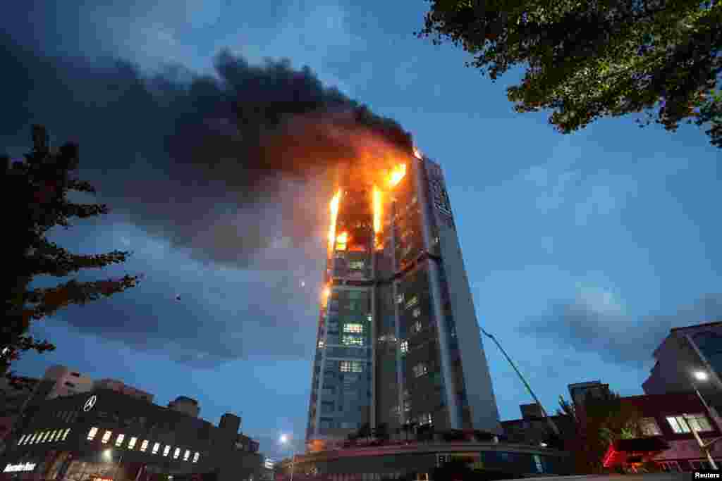 A mixed-use high-rise residential building is engulfed by a fire in Ulsan, South Korea. (Yonhap via Reuters)