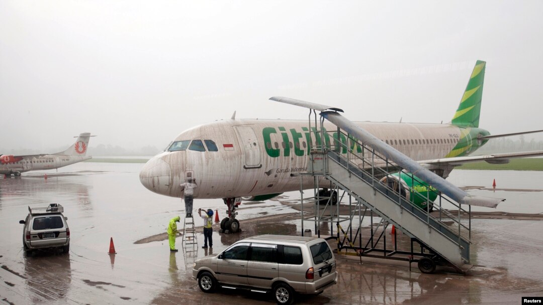 Para pekerja membersihkan abu vulkanik Gunung Kelud dari pesawat milik maskapai penerbangan Citilink di Bandara Adisucipto, Yogyakarta (14/2).