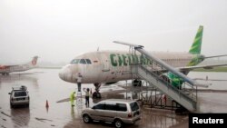 Para pekerja membersihkan abu vulkanik Gunung Kelud dari pesawat milik maskapai penerbangan Citilink di Bandara Adisucipto, Yogyakarta (14/2).