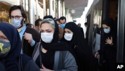 FILE - In this Oct. 11, 2020 photo, people wear protective face masks to help prevent the spread of the coronavirus in downtown Tehran. Iran announced its highest single-day death toll from the coronavirus with 272 people killed.