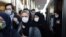FILE - In this Oct. 11, 2020 photo, people wear protective face masks to help prevent the spread of the coronavirus in downtown Tehran. Iran announced its highest single-day death toll from the coronavirus with 272 people killed.