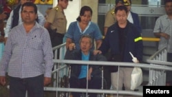 ອະດີດ ປະທານາທິບໍດີ ເປຣູ ທ່ານ Alberto Fujimori, ກາງ, ຢູ່ໃນການດູແລ ໂດຍທ່ານ Kenji Fujimori ລູກຊາຍຂອງທ່ານ, ຂວາ ອອກຈາກໂຮງພະຍາບານ Centenario ໃນລີມາ, ປະເທດເປຣູ, 4 ມັງກອນ 2018.