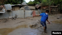 Israel Martínez, camina en el barro cerca de su casa dañada por los huracanes Eta e Iota en Chemelecon, afueras de San Pedro Sula, Honduras 9 de diciembre de 2020.