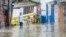 People walk through a street flooded by the rains of Tropical Storm Franklin in Santo Domingo, Dominican Republic, Aug. 22, 2023. 