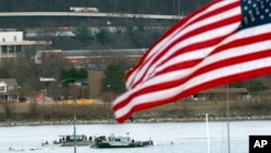 A diving team and police boat work near a wreckage site in the Potomac River near Ronald Reagan Washington National Airport in Arlington, Virginia, Jan. 30, 2025.