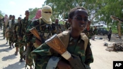 Wapiganaji wa al-Shabaab wakiwa katika mazoezi yao ya kivita, wakiongozwa na mtoto mdogo katika kitongoji cha Suqaholaha, karibu na Mogadishu, Somalia, Januari. 1, 2010. 