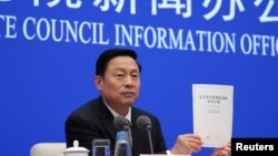 Guo Weimin, Vice Director of the Information Office of China's State Council holds a white paper titled “China’s Position on the China-US Economic and Trade Consultations” at a news conference in Beijing, June 2, 2019. 