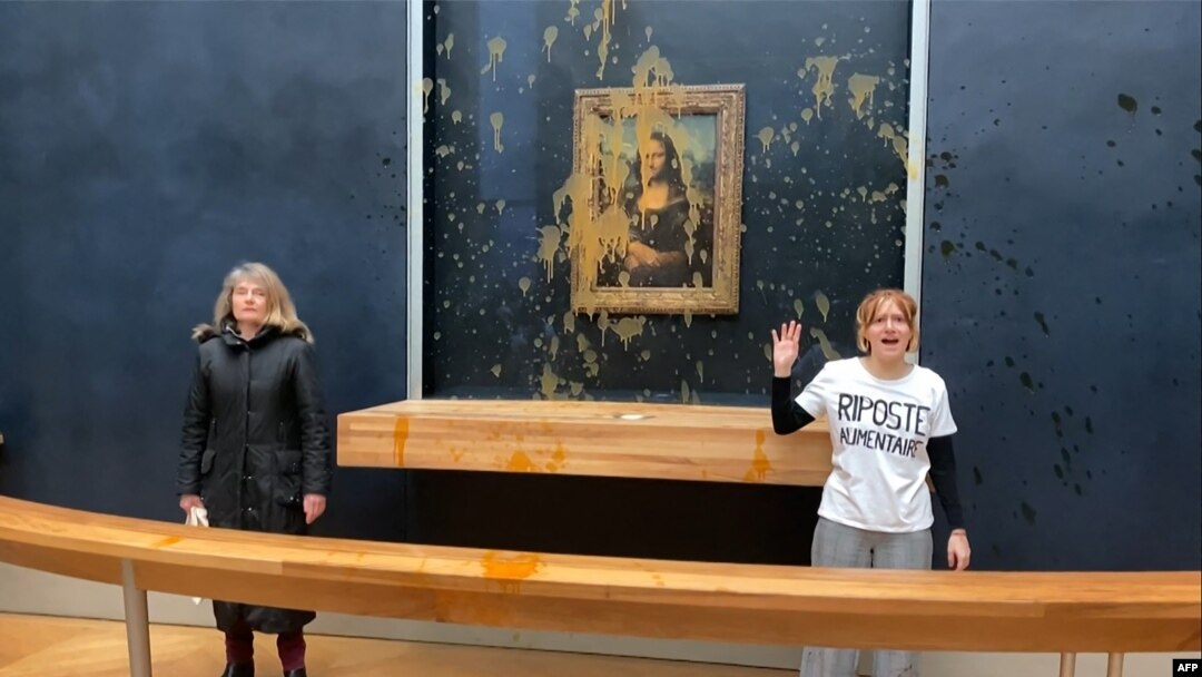 Dua aktivis lingkungan dari kolektif "Riposte Alimentaire" melakukan aksi protes dengan melepar sup ke Lukisan Mona Lisa di museum Louvre di Paris, pada 28 Januari 2024. (Foto: David Cantiniaux/AFPTV/AFP)